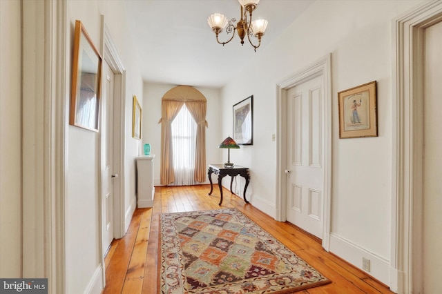 interior space featuring a notable chandelier, light wood-style floors, and baseboards