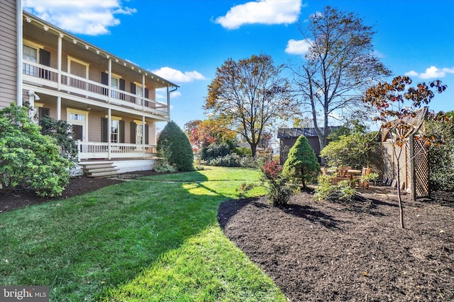 view of yard featuring covered porch and a balcony