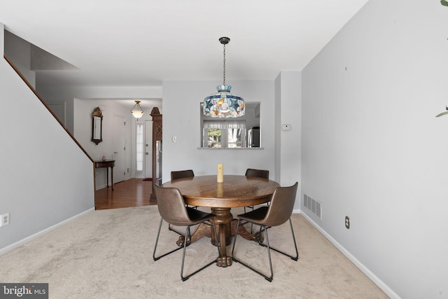 carpeted dining room featuring baseboards and visible vents