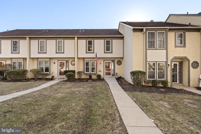 view of property featuring stucco siding and a front lawn