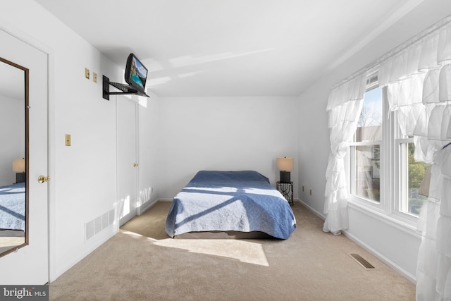 carpeted bedroom with multiple windows, baseboards, and visible vents