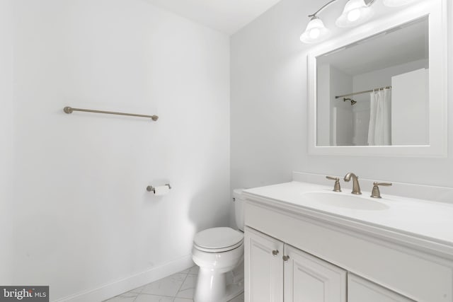 full bath with toilet, marble finish floor, a shower with shower curtain, baseboards, and vanity