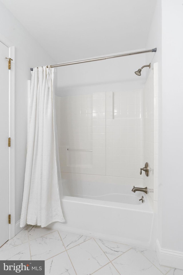 full bathroom with marble finish floor, baseboards, and shower / bathtub combination with curtain