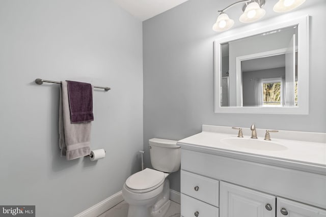 bathroom featuring marble finish floor, toilet, vanity, and baseboards