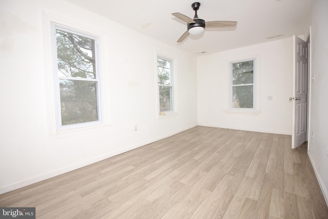 spare room featuring light wood-type flooring, baseboards, and a ceiling fan