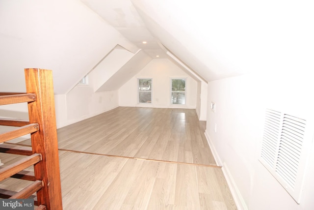 bonus room with visible vents, baseboards, wood finished floors, and vaulted ceiling