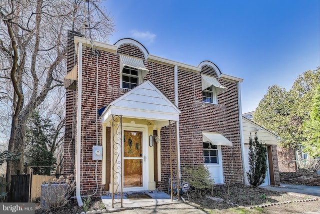 view of front of house with fence and brick siding