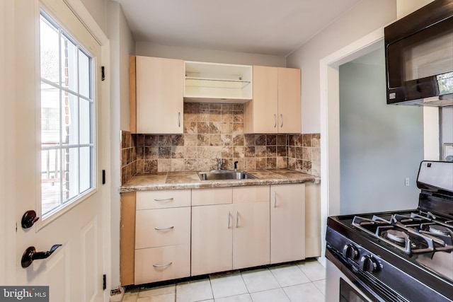 2011 Wardman Rd, Hyattsville, MD 20782 - kitchen featuring stainless steel range with gas cooktop, backsplash, a sink, black microwave, and a wealth of natural light
