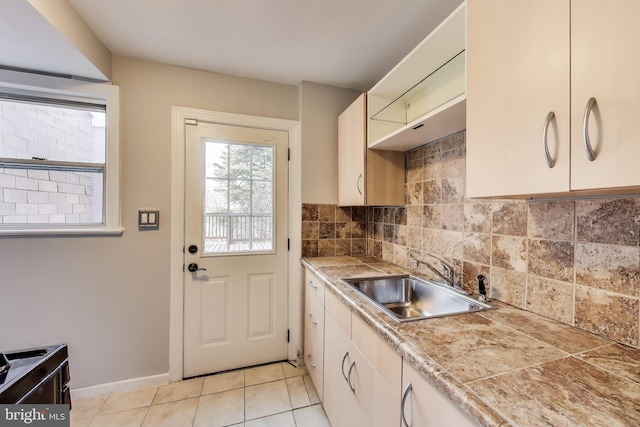 2011 Wardman Rd, Hyattsville, MD 20782 - kitchen with light tile patterned floors, baseboards, tasteful backsplash, and a sink