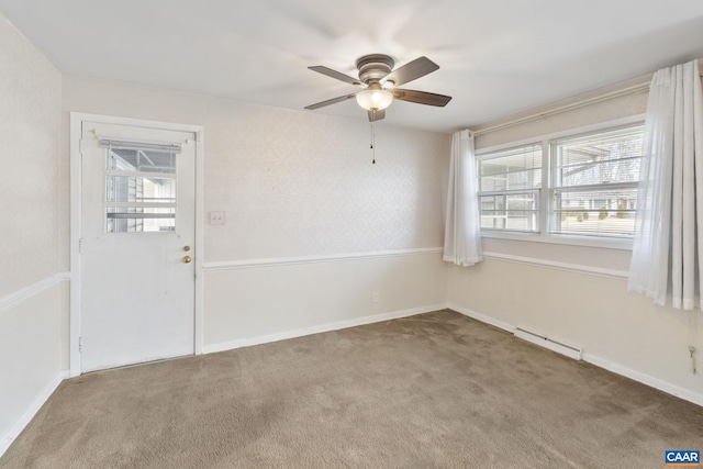 empty room with a ceiling fan, plenty of natural light, carpet, and baseboard heating