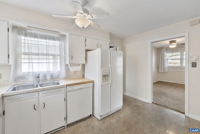 kitchen with a ceiling fan, a sink, white cabinetry, white appliances, and light countertops