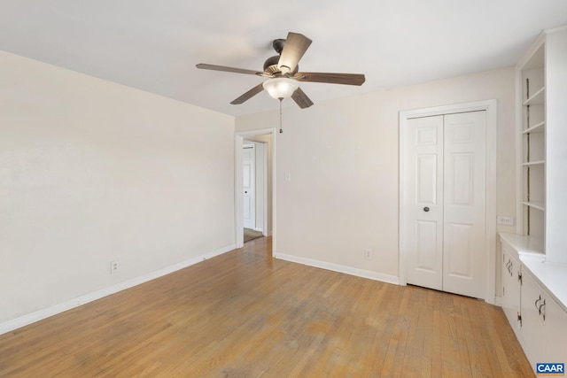 unfurnished bedroom featuring a closet, baseboards, ceiling fan, and light wood finished floors