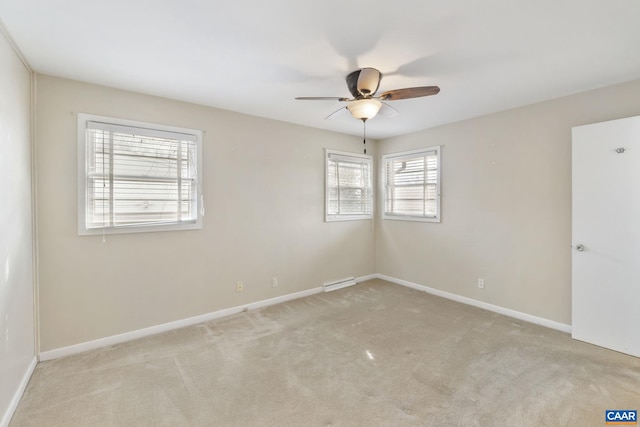 carpeted empty room featuring ceiling fan and baseboards