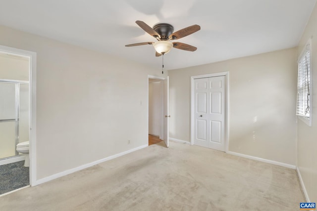 unfurnished bedroom with baseboards, carpet floors, a closet, and ensuite bath