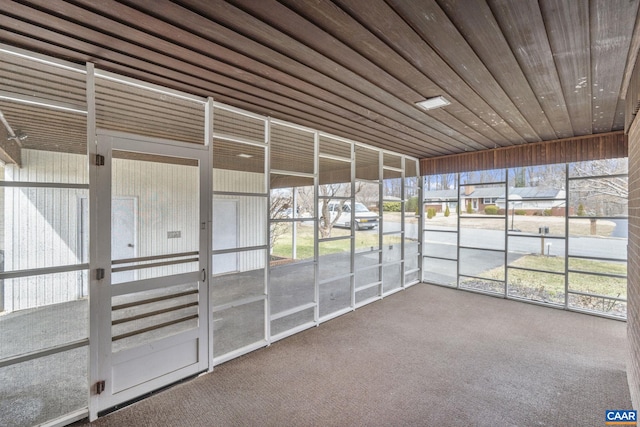 unfurnished sunroom featuring a wealth of natural light, a residential view, and wood ceiling