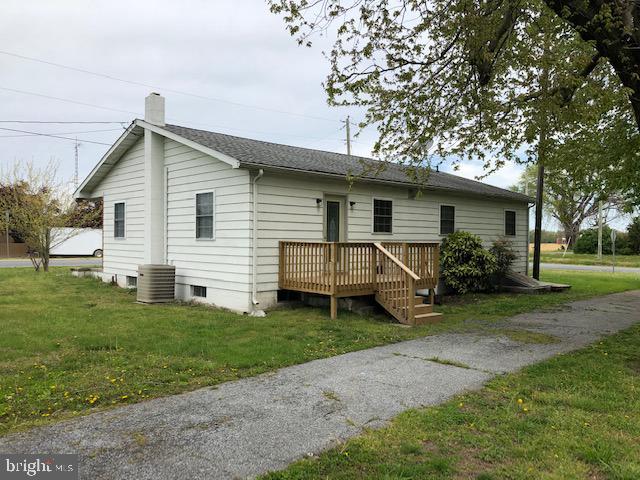 rear view of property with a yard, central AC, a deck, and a chimney