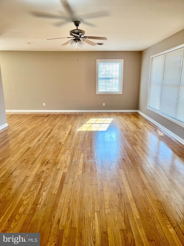 spare room with a ceiling fan, baseboards, and light wood finished floors