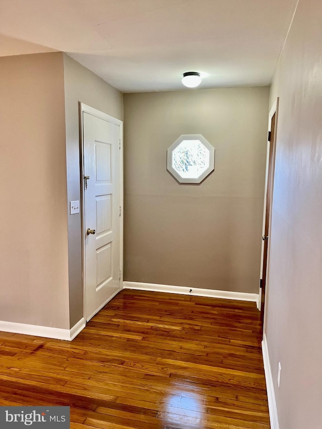 interior space with baseboards and dark wood-style floors