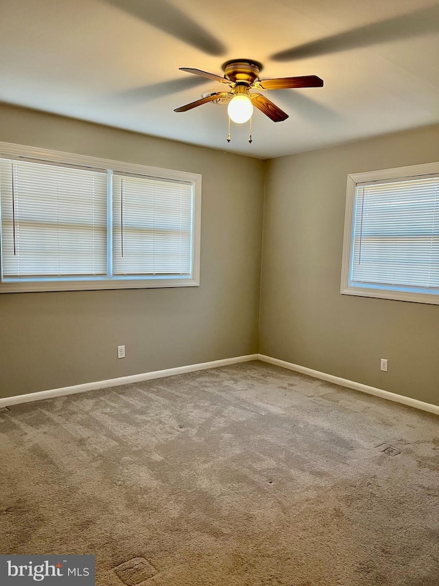 spare room with baseboards, carpet floors, and ceiling fan