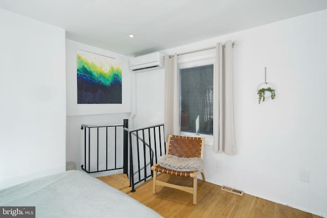 interior space featuring a wall mounted air conditioner, visible vents, wood finished floors, and recessed lighting