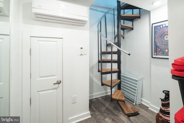 stairs featuring a wall unit AC, wood finished floors, and baseboards