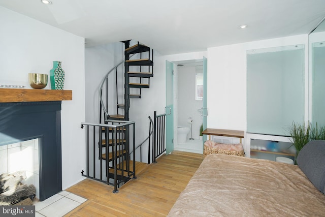 interior space featuring recessed lighting, ensuite bath, and wood finished floors