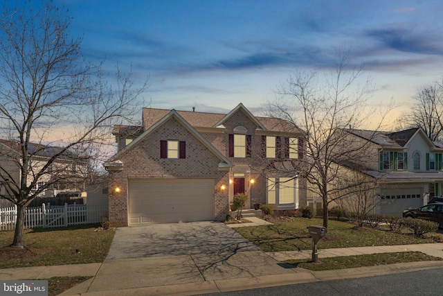 traditional-style home featuring brick siding, an attached garage, concrete driveway, and fence