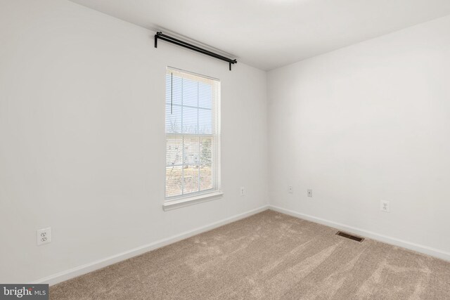 spare room featuring visible vents, baseboards, and carpet flooring