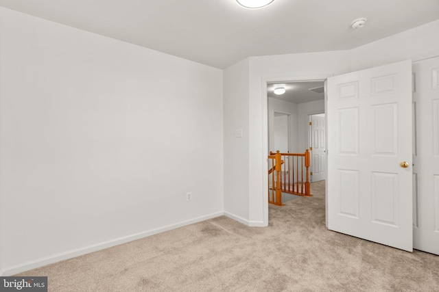 unfurnished bedroom with baseboards and light carpet