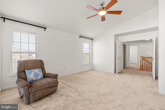 living area featuring light colored carpet, baseboards, and vaulted ceiling