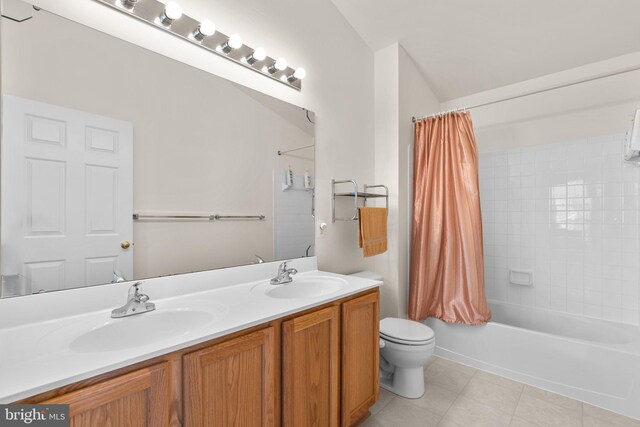 full bathroom with a sink, toilet, double vanity, and tile patterned flooring