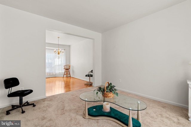 living area featuring a notable chandelier, baseboards, and carpet floors