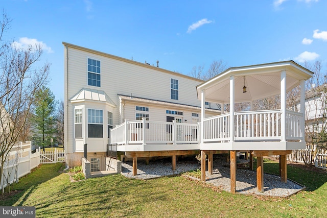 back of house featuring a yard, a deck, and fence