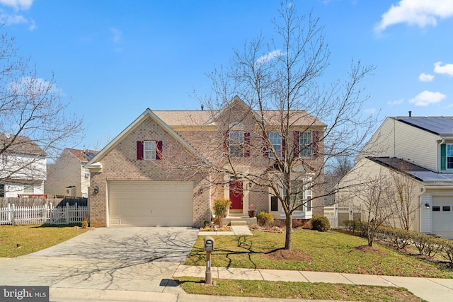 traditional-style home featuring a front yard, fence, concrete driveway, a garage, and brick siding