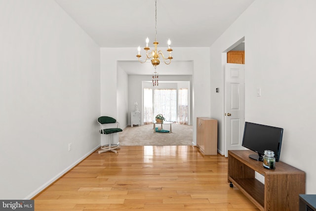 dining room with a chandelier, baseboards, and wood finished floors