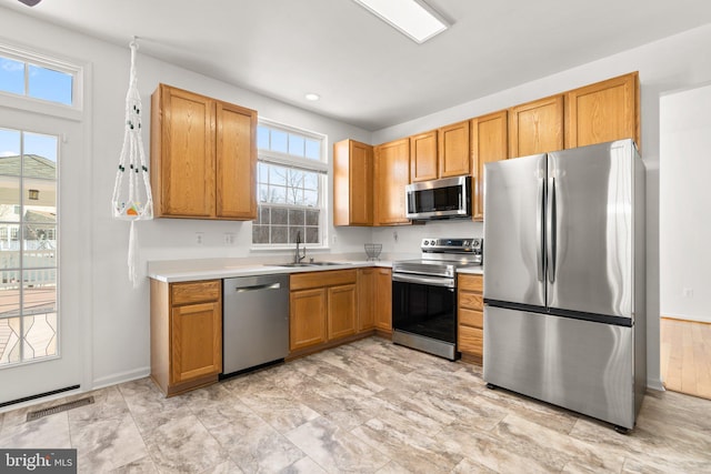 kitchen with baseboards, visible vents, a sink, stainless steel appliances, and light countertops