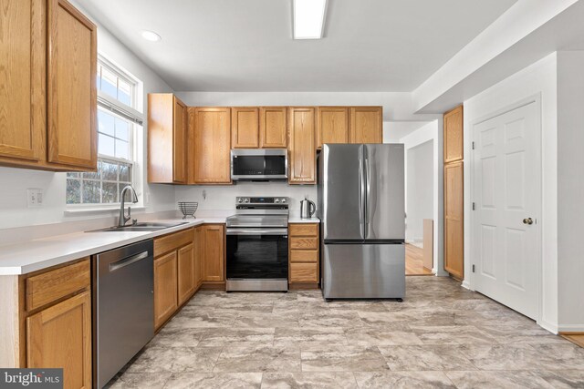 kitchen featuring appliances with stainless steel finishes, light countertops, and a sink