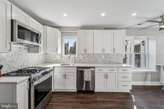 kitchen featuring a sink, stainless steel appliances, light countertops, white cabinetry, and backsplash