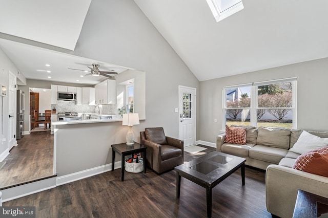 living room with dark wood-style floors, baseboards, high vaulted ceiling, a skylight, and recessed lighting