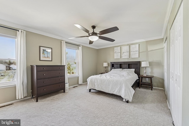 bedroom featuring visible vents, crown molding, ceiling fan, baseboards, and carpet floors