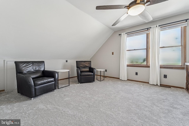 living area featuring baseboards, carpet floors, ceiling fan, and vaulted ceiling