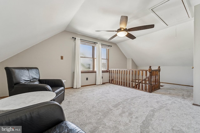 sitting room featuring baseboards, an upstairs landing, attic access, and vaulted ceiling