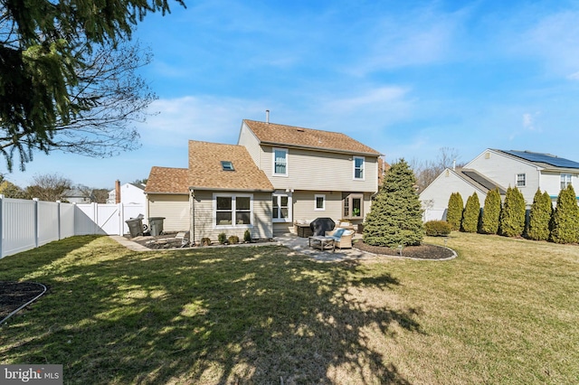 rear view of house featuring a fenced backyard, a yard, a patio, and roof with shingles