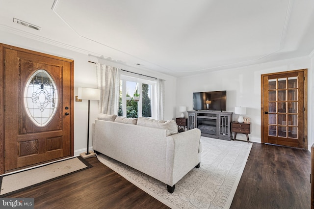 interior space featuring visible vents, dark wood-style floors, a fireplace, crown molding, and baseboards