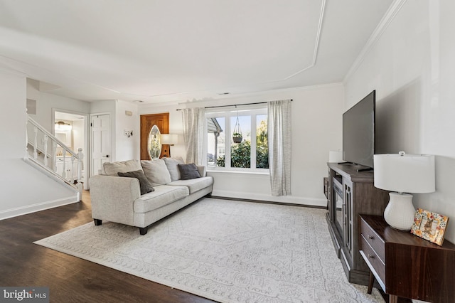 living area with stairs, wood finished floors, baseboards, and ornamental molding