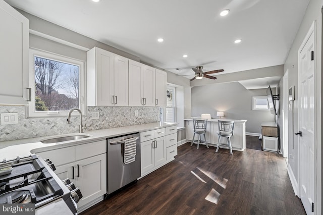 kitchen featuring white cabinetry, dark wood finished floors, a sink, stove, and dishwasher