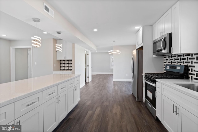 kitchen with dark wood-style floors, visible vents, stainless steel appliances, decorative backsplash, and white cabinetry