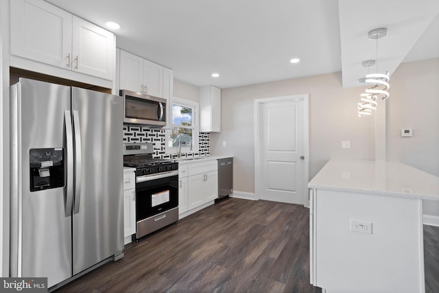 kitchen featuring light stone counters, tasteful backsplash, appliances with stainless steel finishes, white cabinets, and dark wood-style flooring