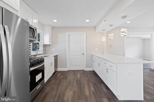 kitchen with a sink, a peninsula, light countertops, and stainless steel appliances