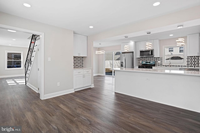 unfurnished living room with recessed lighting, baseboards, and dark wood finished floors